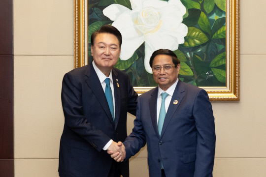 윤석열 대통령이 10일(현지시간) 라오스 비엔티안 국립컨벤션센터(NCC)에서 열린 한·베트남 양자회담에서 팜 민 찐 베트남 총리와 악수하고 있다.<연합뉴스>